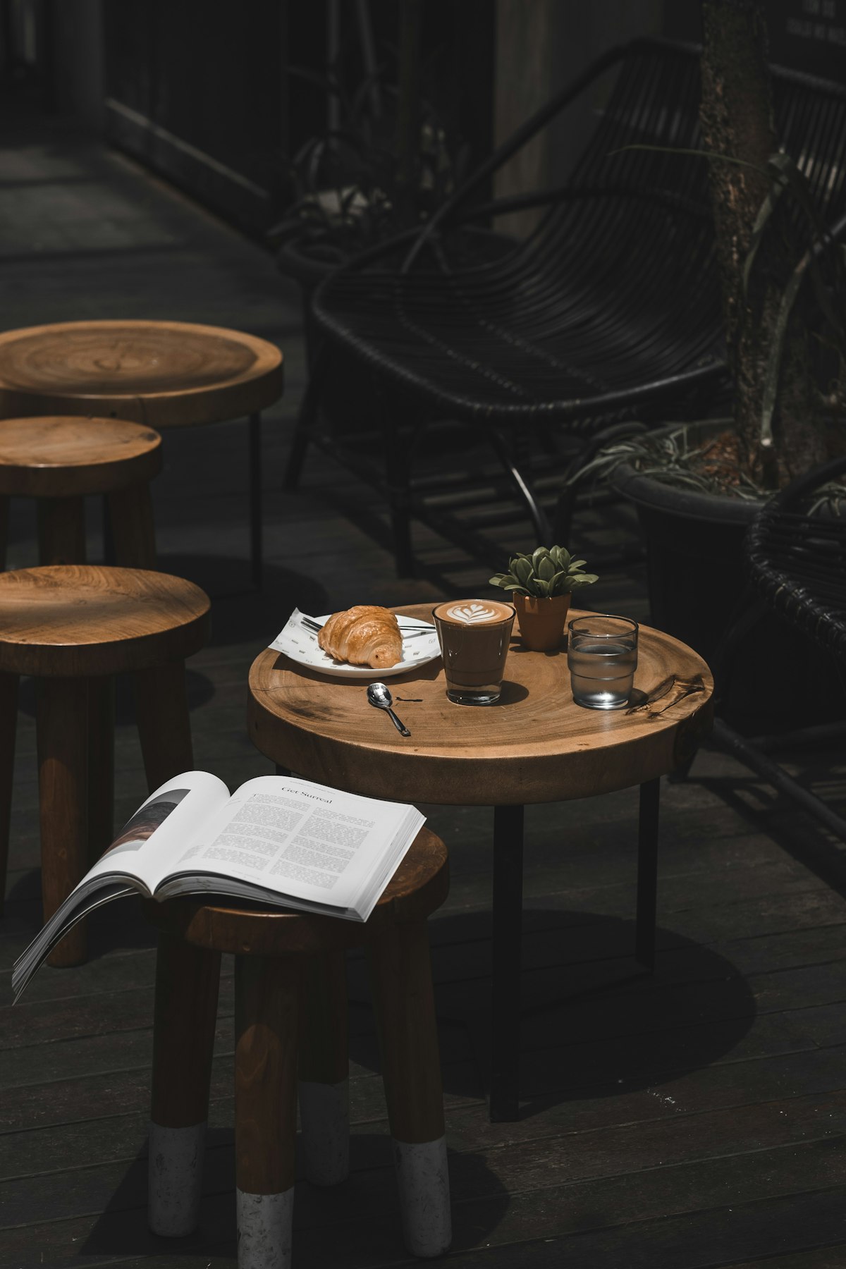 カフェのテラス席。木のテーブルにラテとクロワッサン